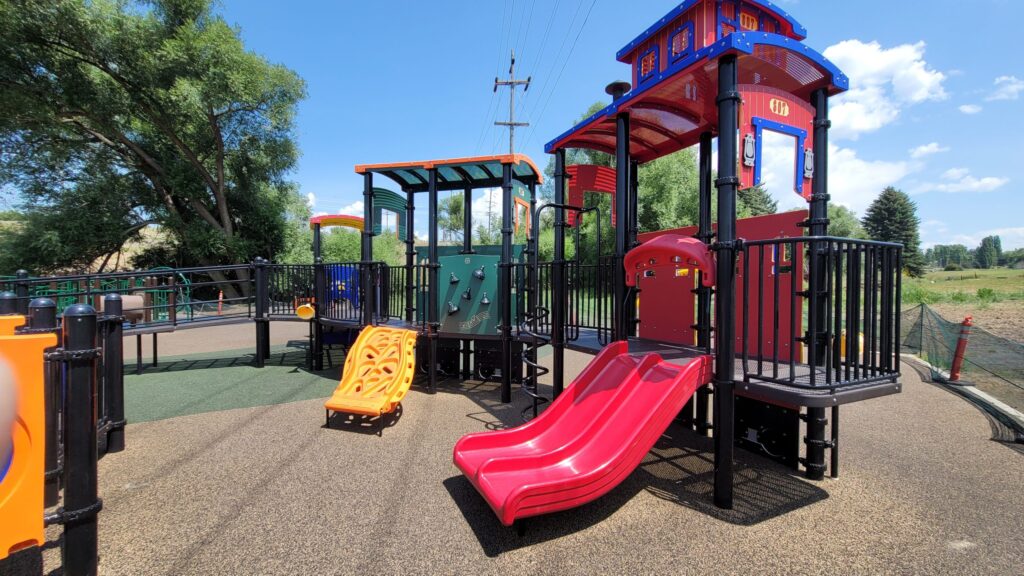 Playground equipment shaped like a train, with a slide and climbing area